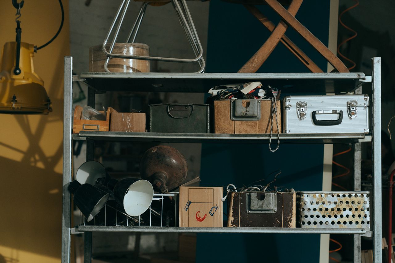 project-03-a A shelf in a workshop holding vintage and retro objects, showcasing old storage boxes and tools.